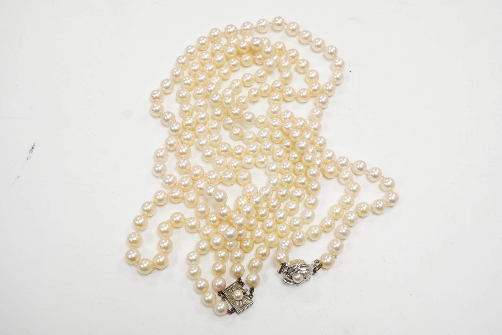 A Mikimoto double strand cultured pearl choker necklace, with cultured pearl set white metal clasp, 38cm, together with a single strand cultured pearl necklace, with cultured pearl set white metal clasp engraved 'silver'